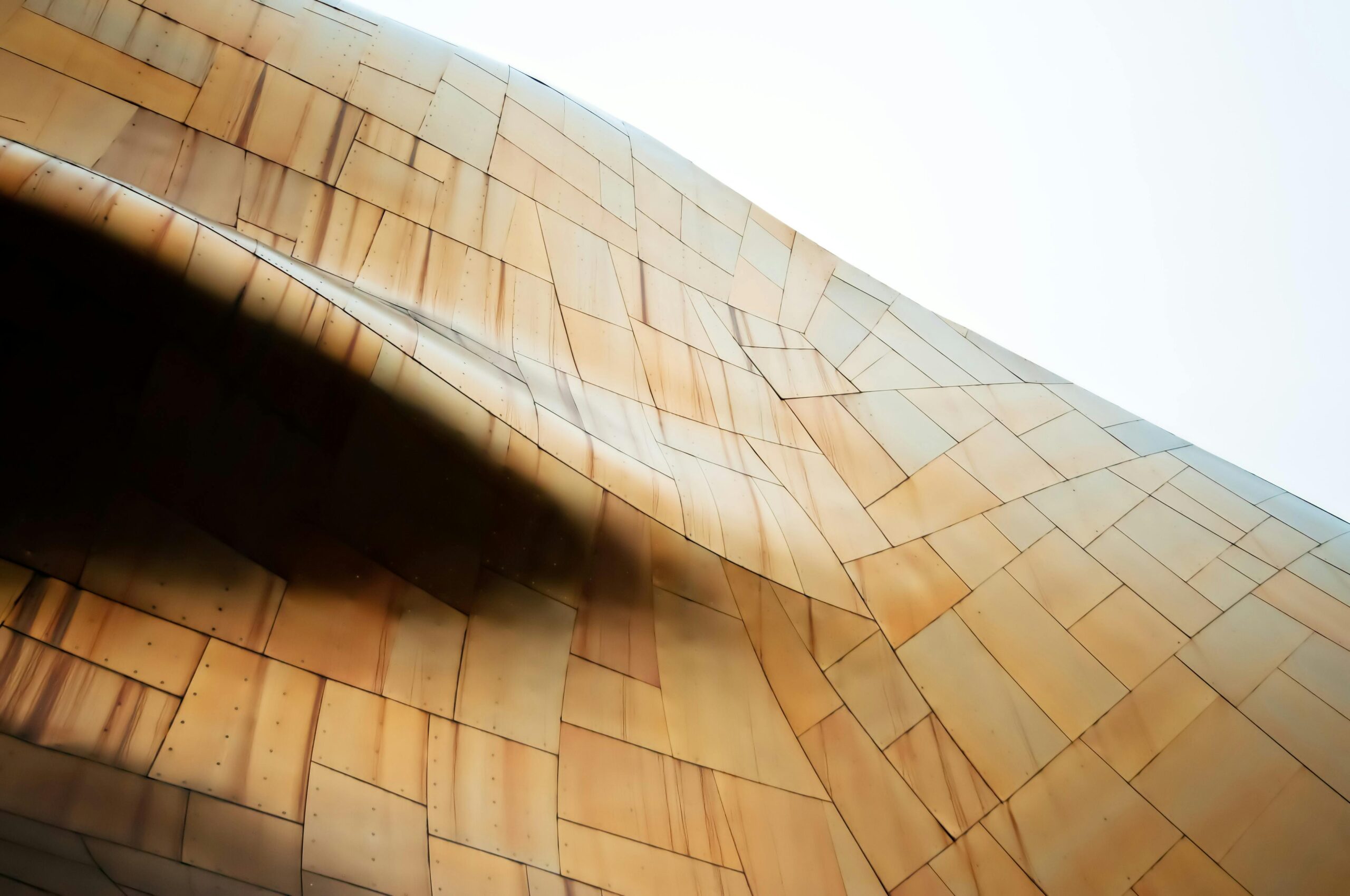 Close-up of modern architecture with a unique bronze metallic facade in flowing contours.